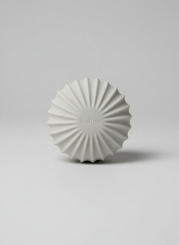 Minimalist 1.5kg weighted Pilates ball (front side) in oat latte silicone for toning and deep muscle engagement