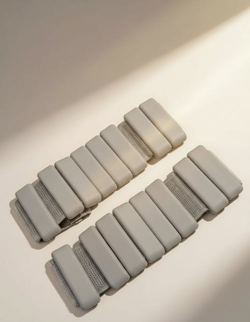 Set of sleek aesthetic andes taupe ankle weights (diagonal view bangles) used for dynamic resistance and toning home workouts