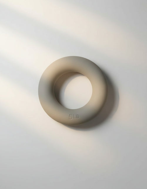 Sleek andes taupe Pilates ring used for strength and inner thigh resistance exercises.